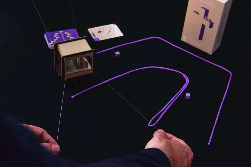 Cofre y tarjetas con cable morado, piezas metálicas y cajas de madera